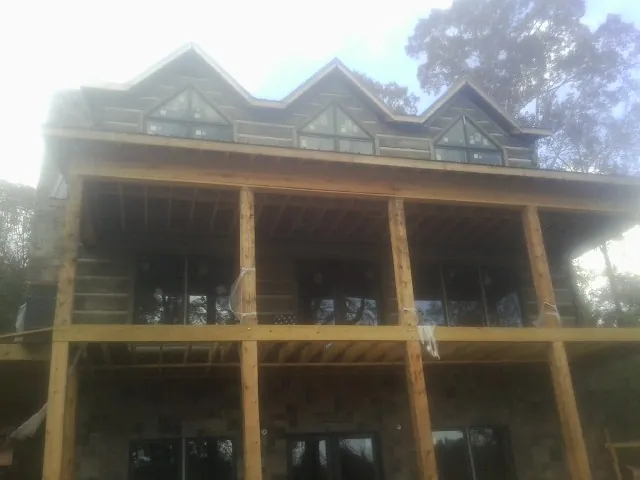 Dormers and porch framing on a large log home under construction — Roof Coating work by our crew in New Holland